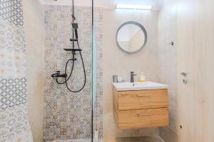 un bagno con doccia, lavandino e specchio di Arctic Apartment a Braşov Altre 7 foto