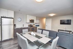 Una cocina y un comedor con mesa y sillas. en Clifton Hill Hideaway 2b -two Bedroom Condo, en Niagara Falls