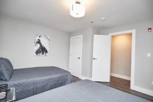 1 dormitorio con 2 camas y puerta a otra habitación en Clifton Hill Hideaway 2b -two Bedroom Condo, en Niagara Falls