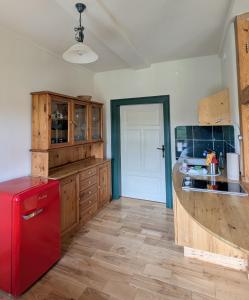 a kitchen with a red refrigerator and wooden cabinets at Oben im Selketal in Harzgerode