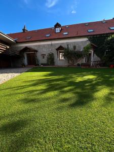 a large yard with a house with a large shadow at Penzion u Svatého Prokopa in Středokluky +11 photos