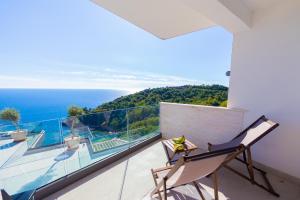 a balcony with a chair and a view of the ocean at Villas Vita & Dola in Budva