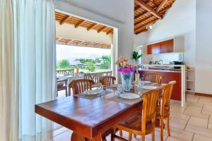 a kitchen and dining room with a wooden table and chairs at Blue Horizon - La Villa Sora - Pool - Sea view in Punaauia