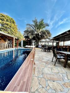 una piscina con mesas y bancos al lado de en Inside Afrika Boutique Hotel, en Kigali