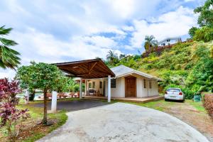 a house with a car parked in the driveway at Blue Horizon - La Villa Sora - Pool - Sea view in Punaauia