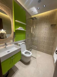 Un baño verde con inodoro y lavabo. en Atlantis Hotel, en El Cairo