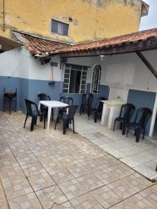 een patio met stoelen en tafels en een gebouw bij Casa da vó julieta in Aparecida +23 foto's