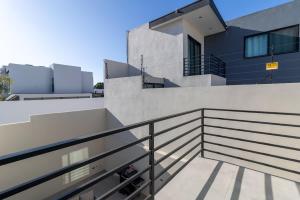 a person sitting on the balcony of a house at Casa Florencia Ensenada Home 3BR WIFi & BBQ 10 Guests in Ensenada