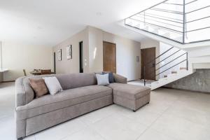 a living room with a couch and a staircase at Casa Florencia Ensenada Home 3BR WIFi & BBQ 10 Guests in Ensenada