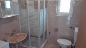 a bathroom with a shower and a toilet and a sink at Apartman Jednosoban, Dvosoban, Trosoban in Sukošan +67 photos