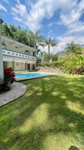 a house with a yard with a swimming pool at Hospedaje Los Pavo Reales in Tepoztlán