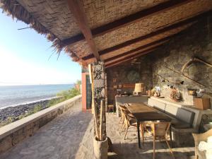a restaurant with a table and chairs on the beach at Casa Praia Tarrafal de Monte Trigo in Seladinha