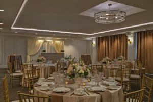 a banquet room with tables and chairs and a chandelier at The Publisher, Downtown Fredericksburg, a Tribute Portfolio Hotel in Fredericksburg