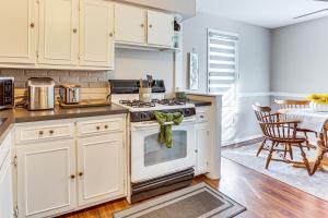 a kitchen with white cabinets and a stove top oven at Cozy Home 4 Mi to YSU Campus Penguins Welcome! in Boardman +17 photos