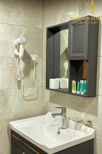 a bathroom with a sink and a hair dryer at Horizon Star Golden Camp in Wadi Rum