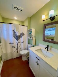 a bathroom with a chicken shower curtain and a sink at Fantastic Vacation Rental on an Authentic Farm in Hartland, Vermont in Sheddsville