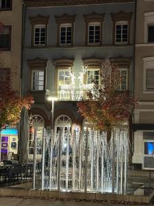 a fountain in front of a building at night at Good Vibes Luxury Homes in Kaiserslautern