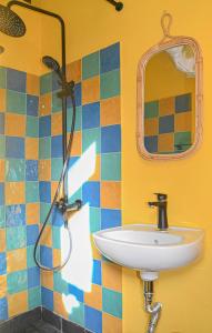 un baño con lavabo y espejo en La Maison ZiaZen, en Porto da Cruz