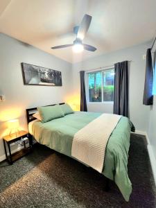 een slaapkamer met een bed en een plafondventilator bij Modern 2BR SPA Retreat in Shawnigan Lake