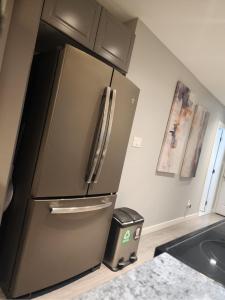 einen Kühlschrank aus Edelstahl in einer Küche mit einem Mülleimer in der Unterkunft Cozy 2BR SPA Retreat in Shawnigan Lake