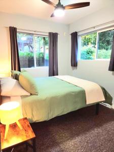 een slaapkamer met een groot bed en twee ramen bij Modern 2BR SPA Retreat in Shawnigan Lake