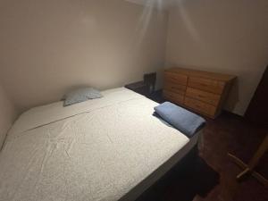 a small bedroom with a bed and a wooden dresser at Hostel Wayra Wasi in Lima +1 photo