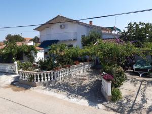 a house with flowers and plants in a yard at Apartman Jednosoban, Dvosoban, Trosoban in Sukošan
