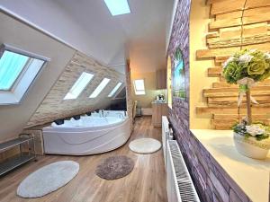 uma grande casa de banho com banheira no meio em Apartman Siesta Bük - Bükfürdő em Bük