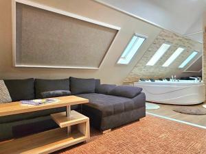 uma sala de estar com um sofá e uma banheira em Apartman Siesta Bük - Bükfürdő em Bük mais 104 fotografias