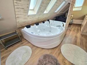 a large bath tub in a room with two rugs at Apartman Siesta Bük - Bükfürdő in Bük