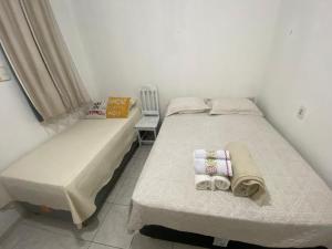 two twin beds in a room with a chair at COP 30 - Imóvel Próximo ao Aeroporto e ao Hangar - 02 in Belém