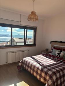 een slaapkamer met een bed en een groot raam bij Alojamiento Fragata Lealtad in Moaña