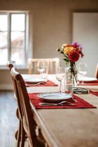 a table with glasses and a vase of flowers on it at Gîte du jardinier in Ittre