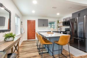 a kitchen with a island with chairs and a refrigerator at Dog Friendly - 8min to Downtown - FAST Wifi in St Petersburg