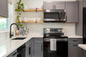 a kitchen with a black stove and a microwave at Dog Friendly - 8min to Downtown - FAST Wifi in St Petersburg