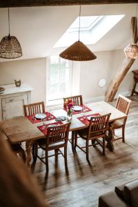 a dining room with a wooden table and chairs at Gîte du jardinier in Ittre