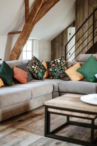 a living room with a couch with pillows on it at Gîte du jardinier in Ittre