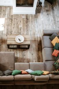 a living room with two brown couches and a table at Gîte du jardinier in Ittre