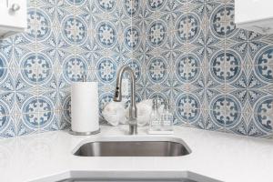 a sink in a kitchen with blue and white tiles at Duplex-Both Units Bungalow A&B Matanzas Launch in St. Augustine +31 photos