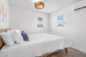 a bedroom with a bed with white sheets and pillows at Duplex-Both Units Bungalow A&B Matanzas Launch in St. Augustine