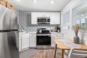 a kitchen with white appliances and a wooden table at Duplex-Both Units Bungalow A&B Matanzas Launch in St. Augustine