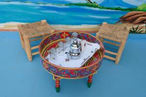 een tafel met een theeservies met twee stoelen bij Studio traditionnel amazigh marocain in Benguerir