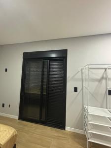 a room with a black door in the wall at Tua Casa no Rosa in Imbituba