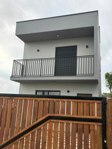 a balcony of a house with a wooden fence at Tua Casa no Rosa in Imbituba
