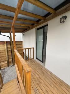 a wooden deck with a glass door on a house at Tua Casa no Rosa in Imbituba +5 photos