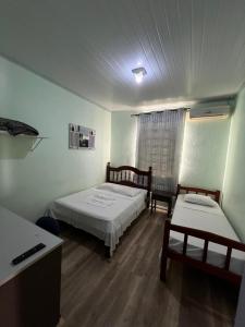 a room with two beds and a table and a desk at Hotel Imperial in Toledo