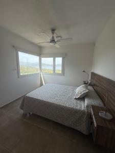 ein weißes Schlafzimmer mit einem Bett und einem Fenster in der Unterkunft Chalet de montaña in Villa Carlos Paz + 12 Fotos