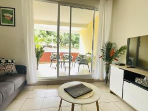 a living room with a couch and a tv at Prestige Lodging City Center in Papeete