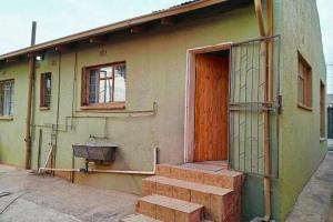 a building with a door and stairs in front of it at Budget Stays at Olivia Pines Guesthouse in Krugersdorp