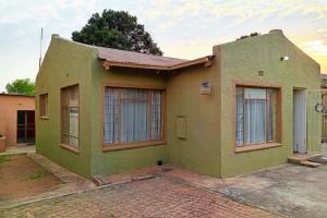 una casa verde con ventanas en una calle en Budget Stays at Olivia Pines Guesthouse, en Krugersdorp